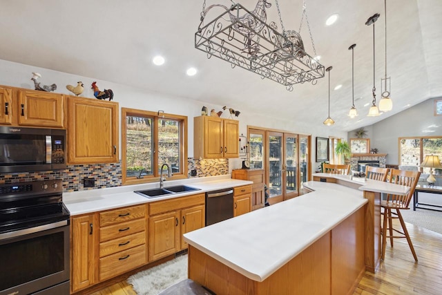 kitchen with sink, a center island, stainless steel appliances, tasteful backsplash, and vaulted ceiling