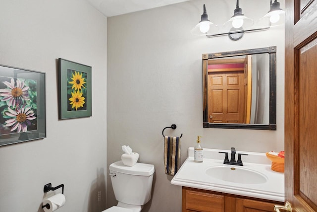 bathroom featuring vanity, toilet, and a chandelier