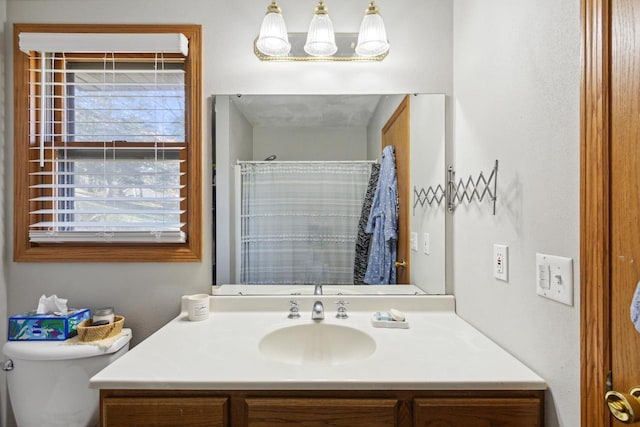 bathroom with a shower with curtain, vanity, a healthy amount of sunlight, and toilet