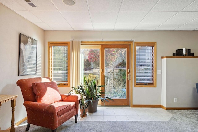 sitting room with a paneled ceiling and light colored carpet