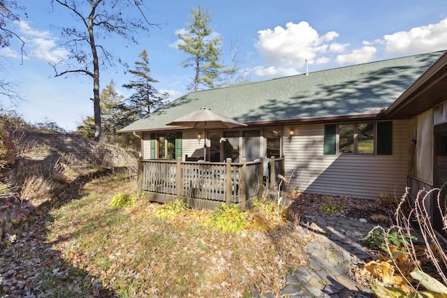 rear view of house featuring a wooden deck