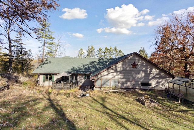 rear view of house with a lawn and an outdoor structure