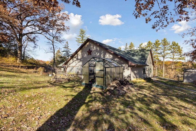 view of home's exterior featuring a lawn and an outdoor structure