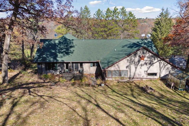 rear view of property featuring a lawn