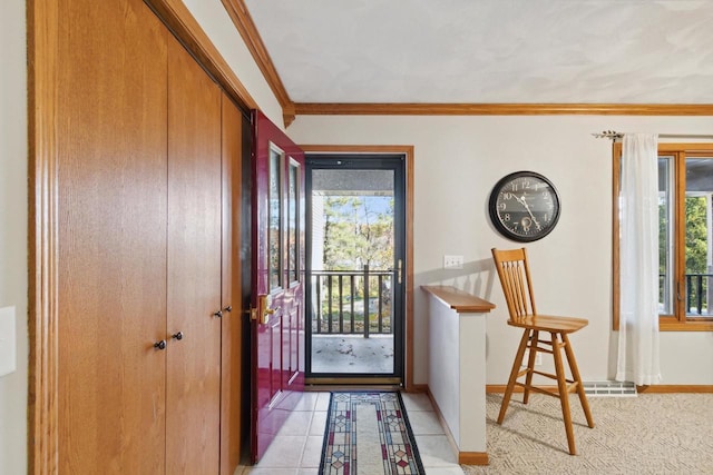 tiled entrance foyer featuring plenty of natural light and crown molding