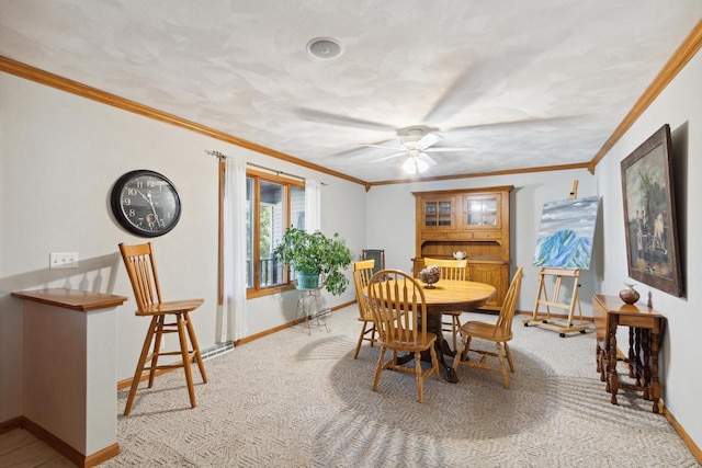 carpeted dining room featuring ceiling fan and ornamental molding