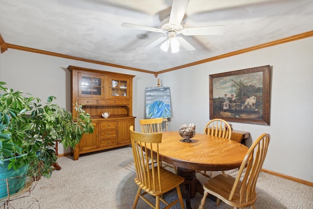 carpeted dining area featuring ceiling fan and crown molding