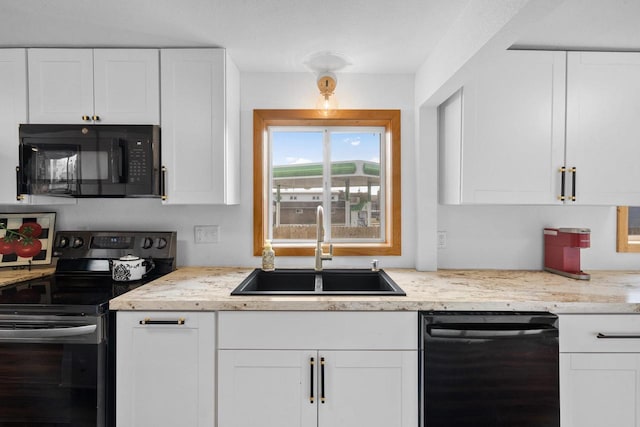 kitchen with black appliances, white cabinets, and sink