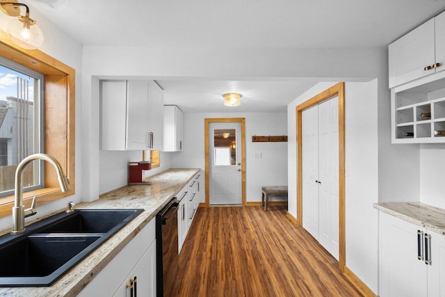 kitchen featuring sink, dark wood-type flooring, black dishwasher, light stone counters, and white cabinets