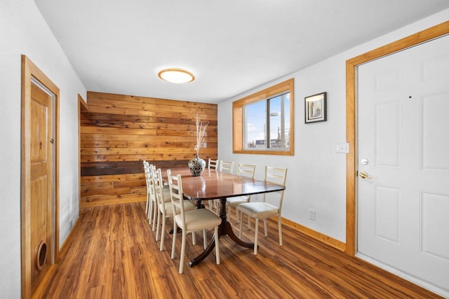 dining area featuring wood walls and dark hardwood / wood-style floors