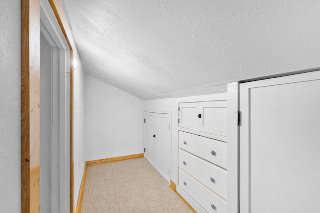 bonus room featuring light colored carpet, a textured ceiling, and vaulted ceiling