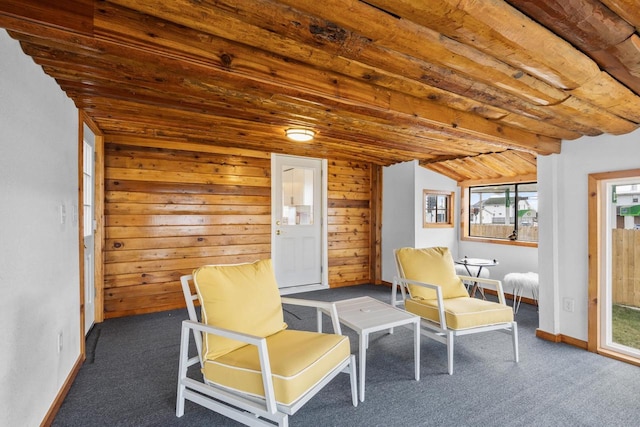 unfurnished room featuring dark colored carpet, vaulted ceiling with beams, wood walls, and wooden ceiling