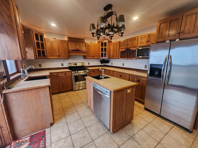 kitchen with a center island with sink, sink, appliances with stainless steel finishes, and an inviting chandelier