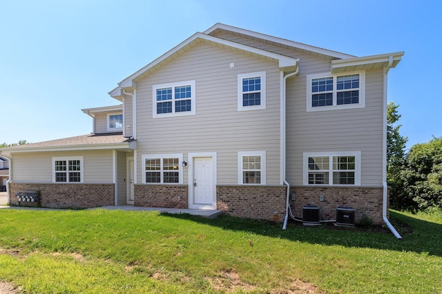 back of house with central AC and a yard