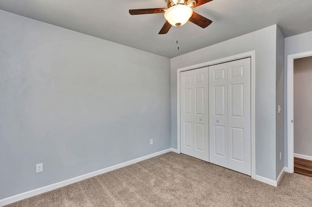 unfurnished bedroom featuring ceiling fan, light colored carpet, and a closet