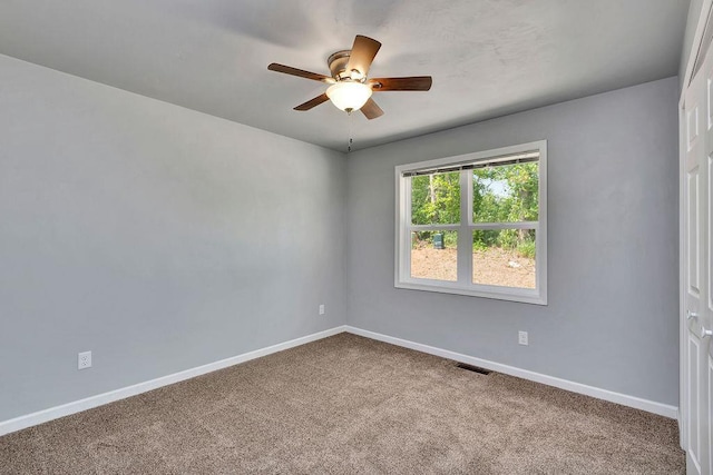 carpeted spare room with ceiling fan