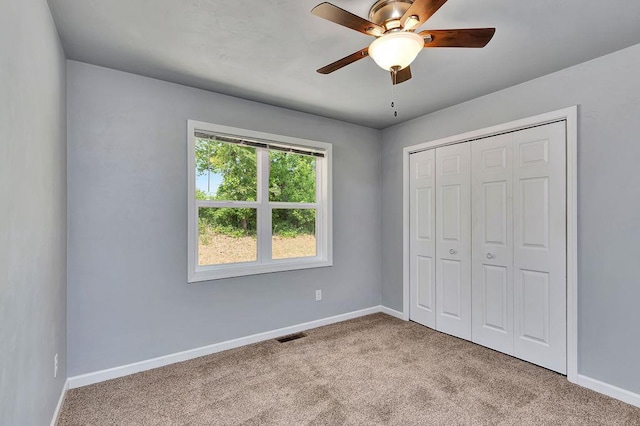 unfurnished bedroom featuring ceiling fan, a closet, and light colored carpet