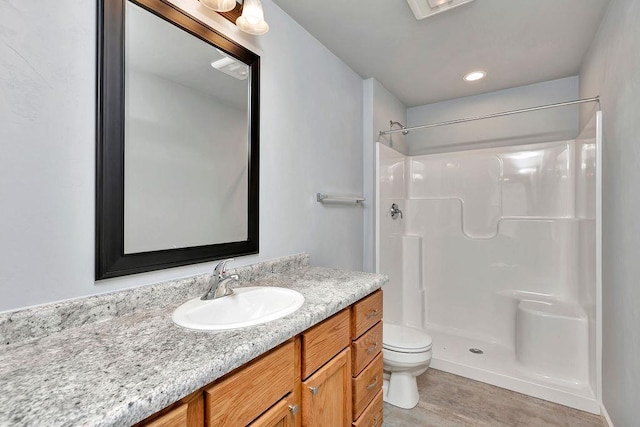 bathroom with a shower, vanity, and toilet