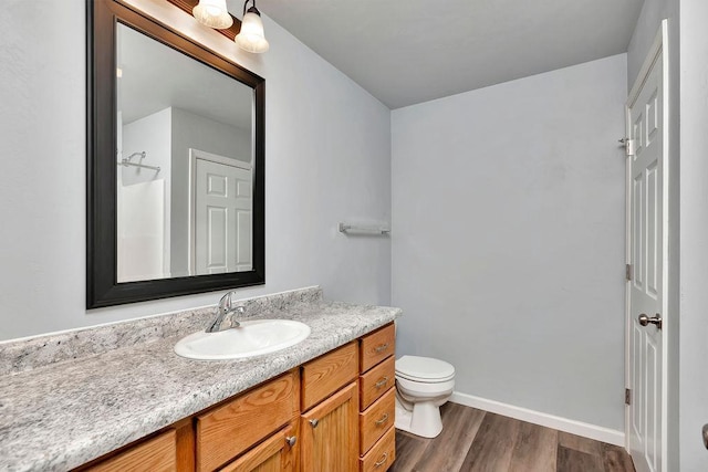 bathroom with hardwood / wood-style flooring, vanity, and toilet