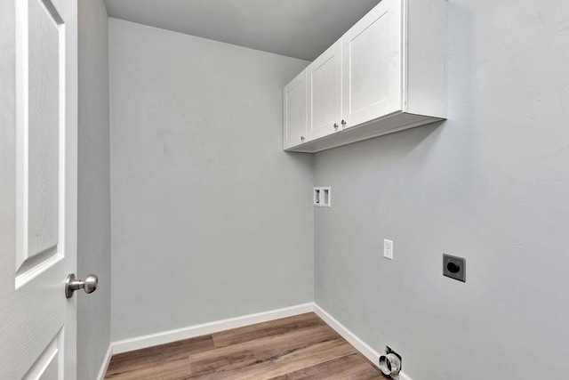 laundry room with hookup for an electric dryer, cabinets, hardwood / wood-style floors, and washer hookup