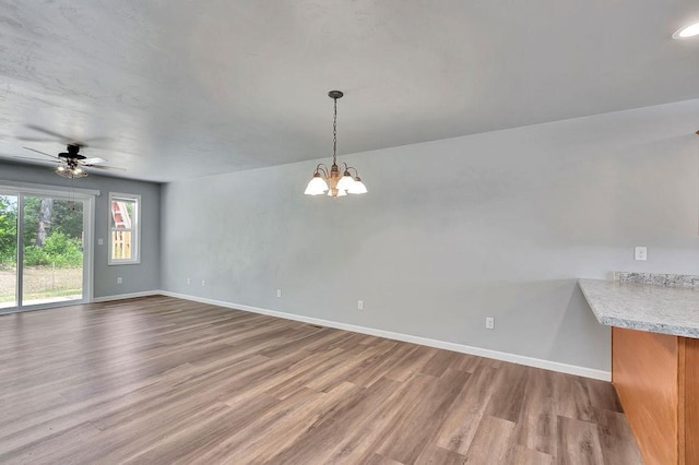 interior space featuring ceiling fan with notable chandelier and light wood-type flooring