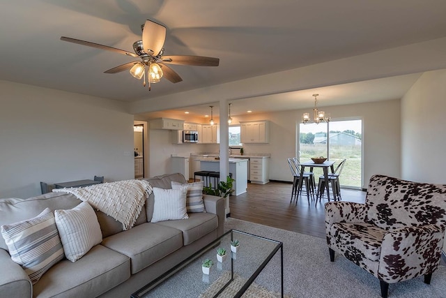 living room featuring hardwood / wood-style floors and ceiling fan with notable chandelier