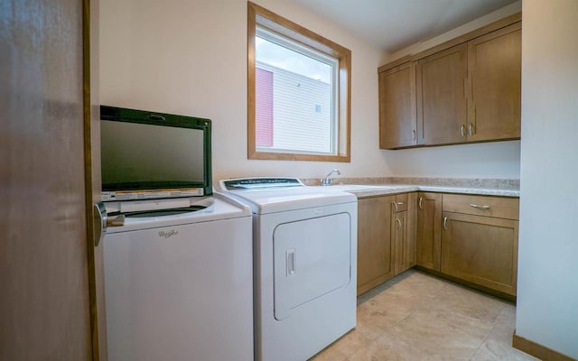 laundry room featuring cabinets, sink, and washer and dryer