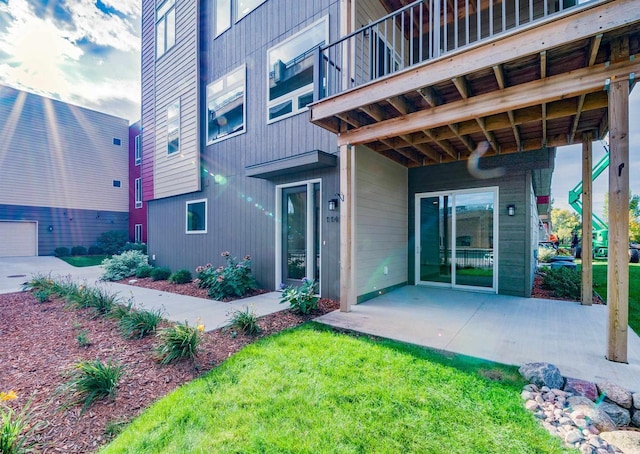 rear view of property featuring a balcony and a patio