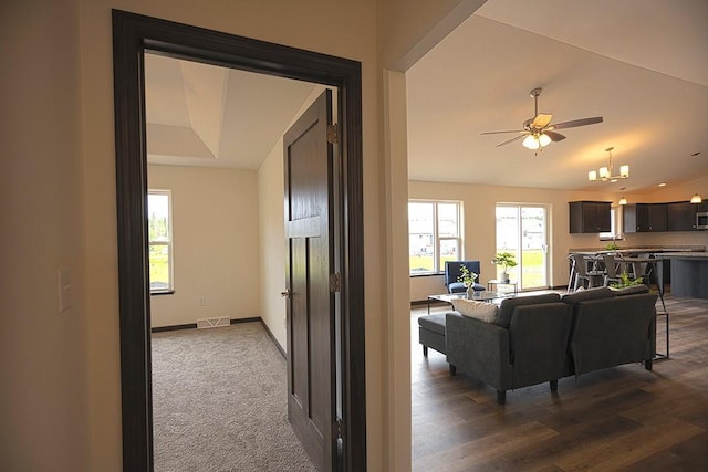 living room with ceiling fan with notable chandelier and lofted ceiling