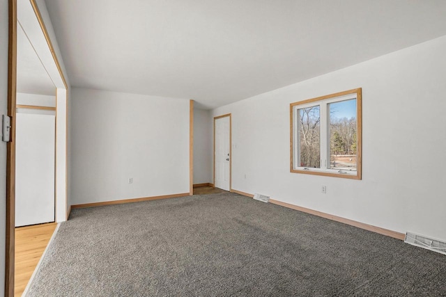 spare room with light colored carpet, visible vents, and baseboards