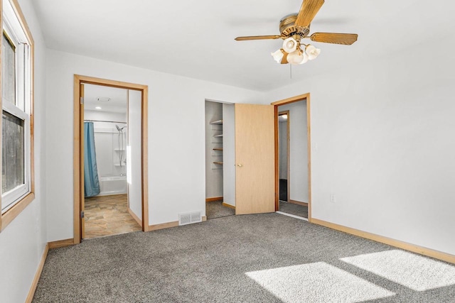 unfurnished bedroom with ensuite bathroom, carpet flooring, visible vents, baseboards, and a closet