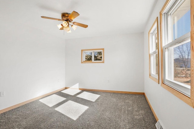 spare room with ceiling fan, carpet flooring, visible vents, and baseboards