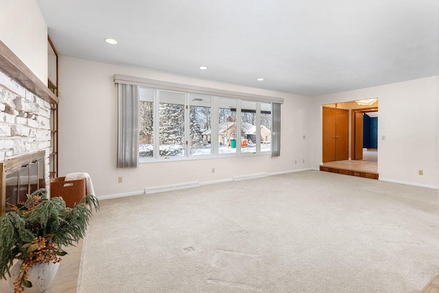 unfurnished living room with a fireplace and light carpet