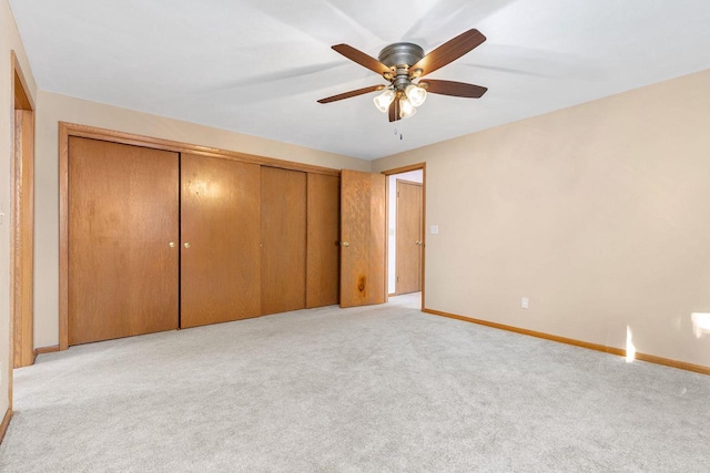 unfurnished bedroom featuring ceiling fan, a closet, and light carpet