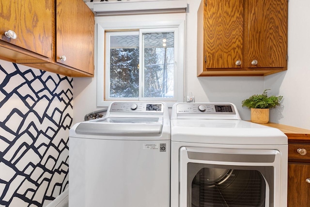 washroom with separate washer and dryer and cabinets