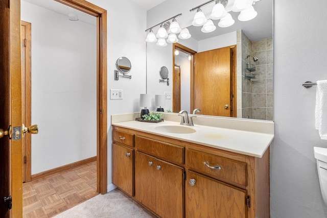 bathroom featuring parquet flooring, vanity, and toilet