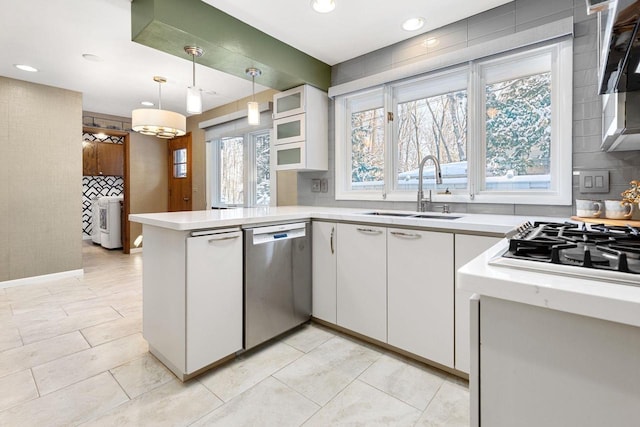 kitchen featuring kitchen peninsula, sink, white cabinets, and stainless steel dishwasher