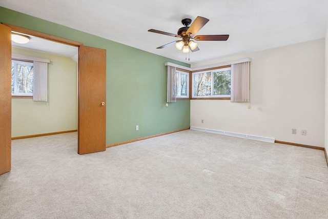 empty room featuring light colored carpet, ceiling fan, and a baseboard heating unit