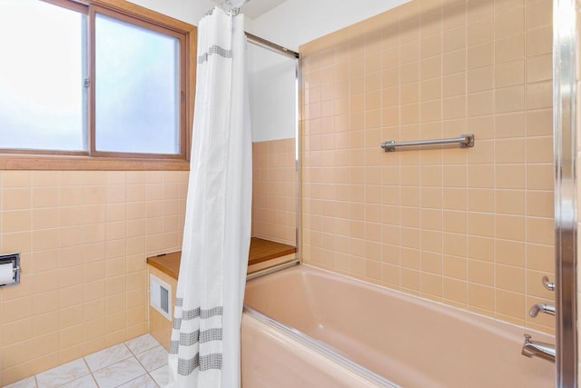 bathroom featuring tile patterned flooring, shower / bath combo with shower curtain, and tile walls