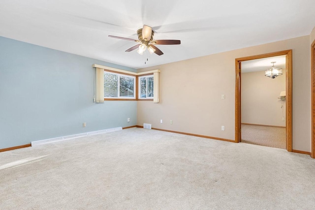 spare room with ceiling fan with notable chandelier, a baseboard radiator, and light colored carpet