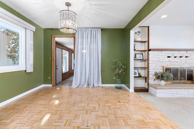 interior space with a chandelier and a stone fireplace