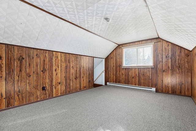 bonus room with carpet floors, vaulted ceiling, baseboard heating, and wooden walls