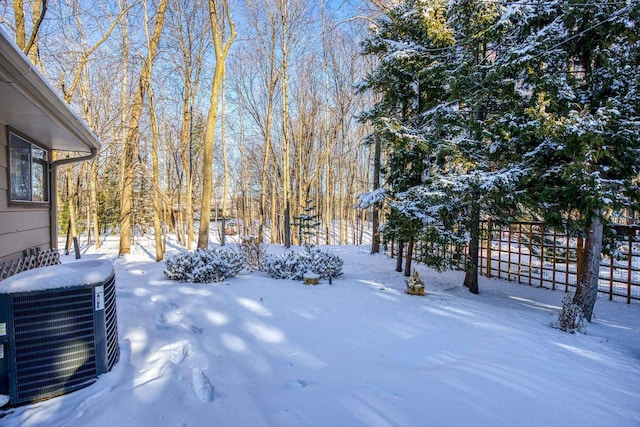 yard layered in snow featuring central AC unit