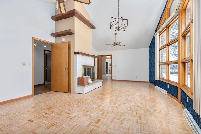 unfurnished living room with baseboard heating, a towering ceiling, light parquet floors, and ceiling fan with notable chandelier