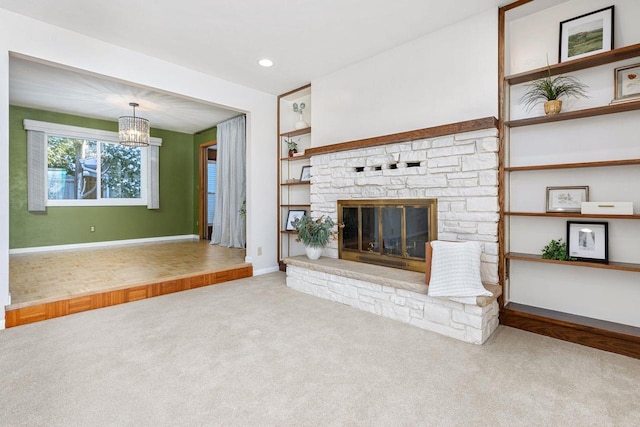 unfurnished living room featuring a fireplace, light carpet, and a chandelier