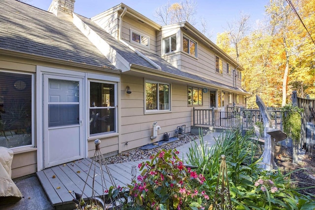 rear view of house featuring a wooden deck