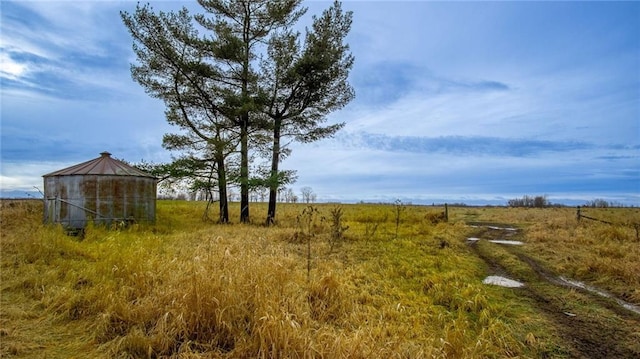 view of yard with a rural view and an outbuilding