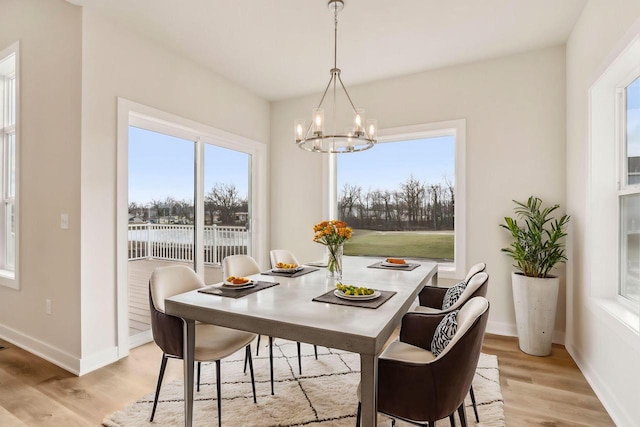 dining room with an inviting chandelier and light wood-type flooring