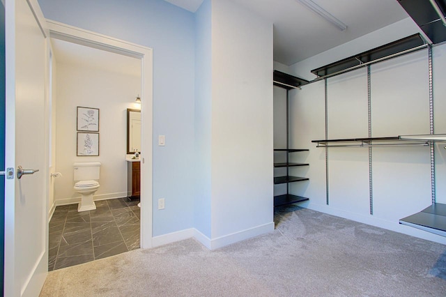 spacious closet with dark carpet