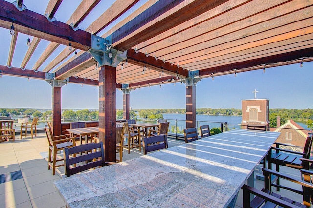 view of patio featuring a bar, a pergola, and a water view